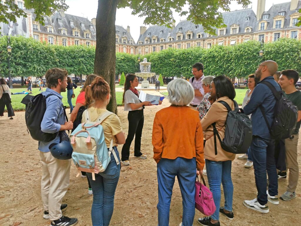 L'animatrice montrer les documents de jeu Place des Vosges